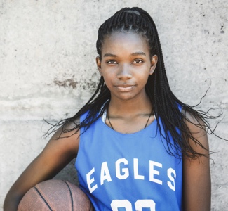Confident female basketball player holding ball