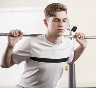 youth engaged in sports exercises with a barbell.
